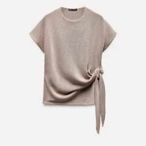 Beige topp med knyt från Zara - Beige T-shirt med knytdetalj från Zara. Använd ett fåtal gånger så väldigt bra skick