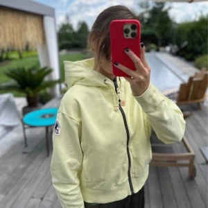 Parajumpers ljusgul hoodie S - Säljer en ljusgul hoodie från Parajumpers med dragkedja och huva. Tröjan har croppad passform, ribbade muddar och en patch på ärmen. 100% authentic.