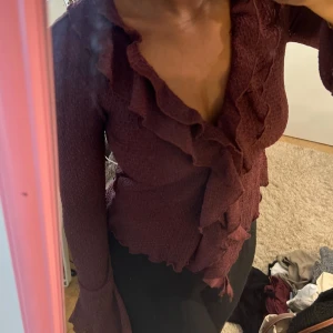 Vinröd omlottblus med volang - Supersnygg vinröd omlottblus med volangdetaljer.