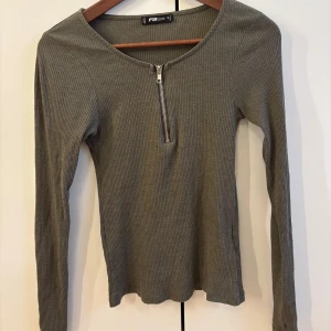 Olivgrön ribbad långärmad topp - Olivgrön ribbad topp  med lång ärm och rundad hals. 