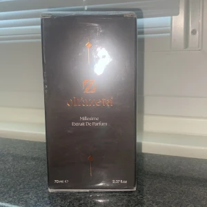 Olfazeta Millesime Extrait De Parfum - Lyxig parfym från Olfazeta, Millesime Extrait De Parfum i en elegant svart kartong med kopparfärgade detaljer. Flaskan rymmer 70 ml och doften är intensiv och exklusiv, perfekt för dig som vill sticka ut med en unik signaturdoft.