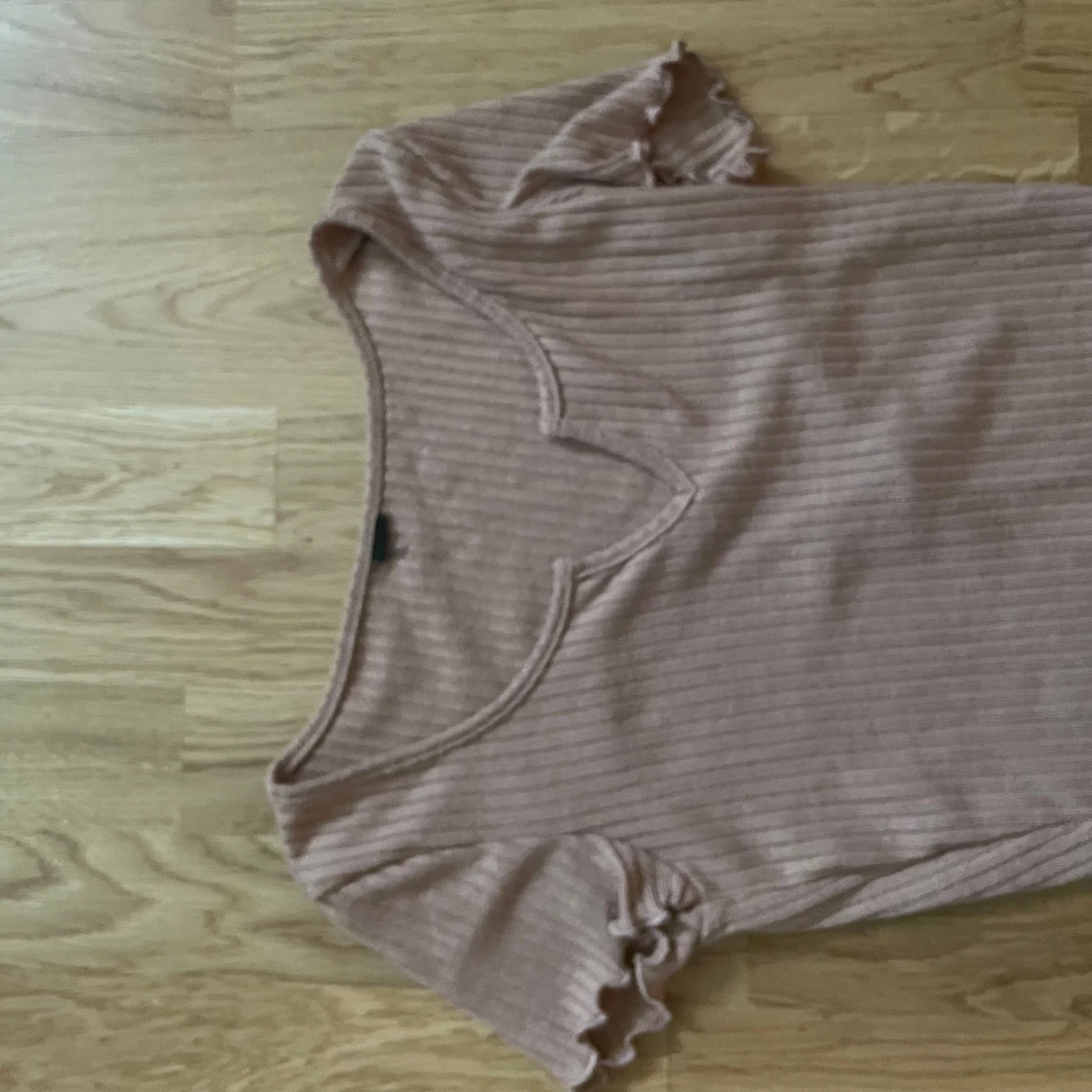 Ljusrosa ribbad topp med volangärm