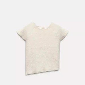 Zara topp - Superfin vit topp i mjukt material med korta ärmar och asymmetrisk nederkant. Toppen har snygg snörning i ryggen som ger en unik look och gör att du kan justera passformen. Endast använd en gång💕💕