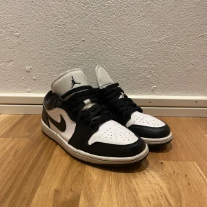Jordan 1 Low svart/vit  - Säljer dessa snygga Jordan 1 low som är sjukt stilrena och passar till det mesta. Skorna är i storlek 41 och skicket på dom är 8,5/10. Köpte de för drygt ett år sedan men har använt de väldigt sparsamt, inga defekter förutom lite creas på framsidan. Original box och andra tillbehör följer inte med.                                          Pris går att diskutera!   