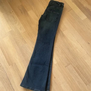 Bootcut jeans från Gina Tricot - Helt nya mörkblå bootcut  low waist jeans från Gina Tricot i storlek 158/164. Klassisk femficksmodell med knapp och dragkedja framtill. Stretchiga och super snygga helt enkelt!