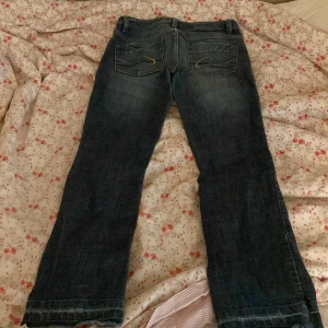 Mörkblå bootcut jeans från Esprit - Säljer ett par mörkblå jeans från Esprit i storlek 36. Modellen är Low waist med bootcut-ben och klassisk femficksdesign med snygga detaljer på bakfickorna. 