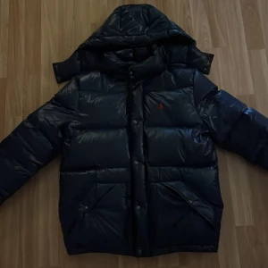Ralph lauren vinterjacka - Snygg blå vinterjacka från Ralph Lauren, skick 10/10 aldrig använd, köpt för ett ex antal år sen så minns inte priset men låg uppskattningsvis runt 2400kr, Storlek XS men passar mig som är runt 166. Priset kommer höjas när vintern kommer så passa på och säkra din vinterjacka redan nu! (Pris kan diskuteras)