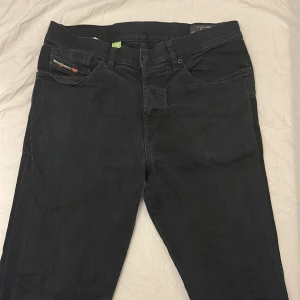 Svarta jeansbyxor från Diesel D-FINING - Säljer ett par svarta jeansbyxor från Diesel, modell D-FINING. Strl W30 L32 Tapered fit som ger en modern och snygg siluett. Knappast använda och som alltid schysst pris som inte är hugget i sten🤩😀☺️