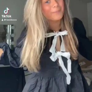 Svart blus med rosett och volang - Säljer en svart blus med långa ärmar och stora vita rosetter framtill. Går att ha åt båda håll. Blusen har volang nedtill och en lös passform. Perfekt för dig som vill ha en trendig och söt look.