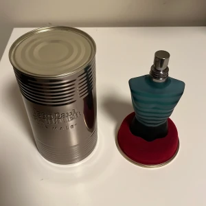 Jean Paul Gaultier Le Male Eau de Toilette - Ikonisk herrparfym i form av en blågrön torsoflaska med metallock. Kommer i en silverfärgad plåtburk. Doften är fräsch och maskulin, perfekt för dig som gillar klassiska och stilrena parfymer. (Bara sprutat 2 sprut) 