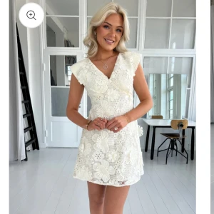 Studentklänning- vit spetsklänning med blommigt mönster - Superfin kort klänning med blommig spets och v-ringning, vitbeige i färgen. Perfekt för studenten. Helt ny och oanvänd, säljer då den inte passade mig! 
