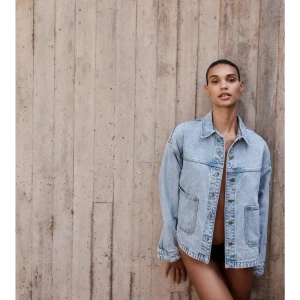 Ljusblå jeansjacka med klassisk krage - Säljer en stilren ljusblå jeansjacka med klassisk krage och stora fickor framtill. Jackan har knappar längs hela framsidan och är långärmad. Perfekt för dig som gillar en avslappnad och trendig look.