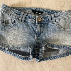Blå jeansshorts från Tally Weijl - Säljer ett par klassiska blå jeansshorts från Tally Weijl. Modellen är lågmidjad med fem fickor, bälteshällor och knappstängning framtill. Perfekta till sommaren och enkla att matcha med olika toppar.💗🤘