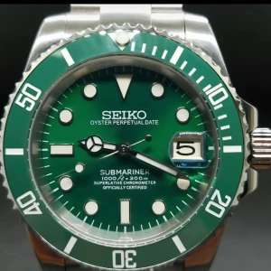 Grön Seiko Submariner klocka - Stilren klocka från Seiko med grön urtavla och grön vridbar bezel. Klockan har datumvisning, tydliga index och silverfärgad länk i metall. Perfekt accessoar för dig som gillar klassisk design med en modern twist.