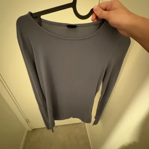Grå långärmad tröja från Gina Tricot - säljer en långärmad ifrån gina med slits vid armarna.