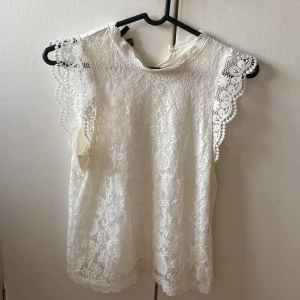 Vit blus topp från Pieces - Säljer en vit blus topp i storlek S från Pieces med spetsdetaljer och volang ärmar. Använd bara vid fina tillfällen så inga defekter eller fläckar💗