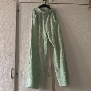 Ljusa gröna byxor från H&M - Säljer ett par ljusa gröna byxor från H&M. Byxorna har en loose passform och är tillverkade i ett lätt och luftigt material, perfekt för varmare dagar. De har en elastisk midja för extra komfort.