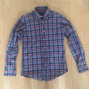 Rutig skjorta från Ralph Lauren storlek S - Säljer min brorsas skjorta från Ralph Lauren i blått, rött och grönt. Skjortan har en slim fit passform och är långärmad med knappar framtill. Storlek S passade han när han var runt 173. Skjortan är i mycket bra skick och endast använd ett fåtal gånger.