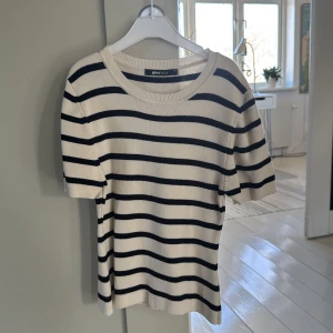 Randig tröja från Gina Tricot - Säljer en stilren randig tröja från Gina Tricot i svart och beige. Tröjan har korta ärmar och en rund halsringning, perfekt för en avslappnad look. Passar bra till både jeans och kjol! Väldigt bekvämt material!!