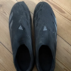 Fotbollsskor från Adidas - Säljer ett par svarta fotbollsskor från Adidas med en strömlinjeformad design och dobbar för bra grepp på planen. Fick dubbar på den strumpan men de stör inget faktiskt.Lite söndriga där fram går o diskutera pris.