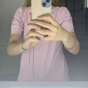 Rosa kortärmad topp - Säljer en söt rosa topp med korta ärmar. Perfekt för en avslappnad stil. Toppen har en enkel design och är gjord i ett mjukt material. Pris kan diskuteras. Använd 2 gånger.