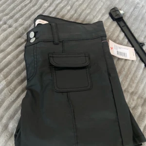 Svarta lågmidjade bootcut jeans från Nelly - Byxerna är 106 lång, 38 i midjan och 83 i innerbenslängd. Snygga svarta lågmidjade bootcut jeans från Nelly med unika fickdetaljer. Perfekta för en trendig look. Passar bra till både vardag och speciella tillfällen. Helt nya med prislap kvar. Samt väldigt fina och säljer slut på sajten fort. Köpte fel storlek så säljer dom.