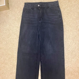 Svarta jeansbyxor - Snygga svarta jeansbyxor med hög midja och klassisk femficksdesign. Byxorna har en rak passform och är långa. 