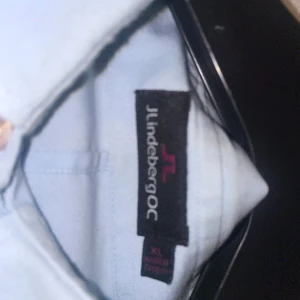 Ljusblå skjorta från J.Lindeberg - Säljer en stilren ljusblå skjorta från J.Lindeberg. Skjortan har långa ärmar och knappar framtill. Perfekt för en elegant look.