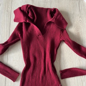 Vinröd ribbad tröja - Snygg vinröd ribbad tröja med v-ringning och långa ärmar. Perfekt för kyligare dagar med sin stilrena design och bekväma passform.🩷🩷