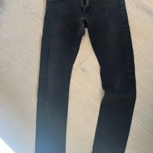 Svarta jeansbyxor fr Lee modell Luke - Snygga svarta jeansbyxor fr Lee, med en klassisk design. De har en rak passform och är perfekta för en stilren look. Byxorna har en dragkedja och knappar framtill. Modell, Luke. Strl 31*32