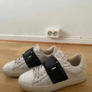Valentinorockstud sneakers  - Valentino Rockstud sneakers i svart med nitar 4 av nitarna har trillat av men inget man tänker på, Skorna är i storlek 37, ett hål i sulan och insidan, fråga om bilder för att se!!! (Endast skor medföljer i köpet)