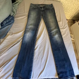 Blå jeans från Replay - Snygga blå jeans från Replay med klassisk femficksdesign och broderade bakfickor. De har en dragkedja och knapp framtill. Perfekta för en avslappnad stil. Det är storlek 30 i midjan.