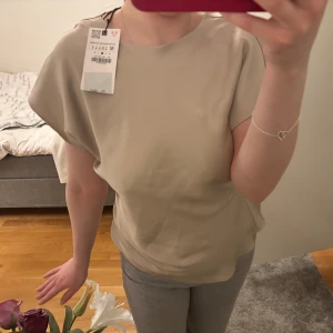 Beige topp från Vila - Säljer en figursydd beige topp från Zara. Champagnefärg. Prislapp är kvar, dvs helt oanvänd!!😇