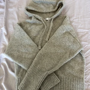 Grå stickad hoodie från Zara - Mysig grå stickad hoodie från Zara med ribbade muddar och dragsko i huvan. I storlek S