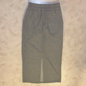 Ny grå ribbad långkjol  - Oanvänd nyköpt grå långkjol med ribbad struktur och en slits baktill, köpt i Hongkong