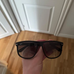 Svarta solglasögon från Ray-Ban - Snygga svarta solglasögon från Ray-Ban boyfriend design. Perfekta för soliga dagar och ger en stilren look. De har en robust båge och mörka linser som skyddar mot solen. Får även med fodral