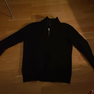 Mörkblå ribbad tröja. - Säljer en half zip tröja i storlek M passar S. Tröjan är slim fit och har en liten defekt på ena axeln.        Skriv vid minsta frågor!