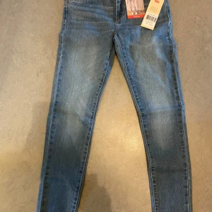 Blå jeans från Levi's - Säljer mina Levis jeans i helt ny skick med pris lapp på aldrig använda! De är i längd 158 cm för 14 åringar hör av er! 
