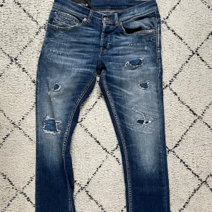 Dondup Jeans - Snygga blå jeans med slitningar från dondup i modellen george. Har haft jeansen ett tag men de är i hysat bra skick och har mycket kvar att ge! Jeansen är i stl 30. Priset är ej hugget i sten och veka inte att skriva vid funderingar.