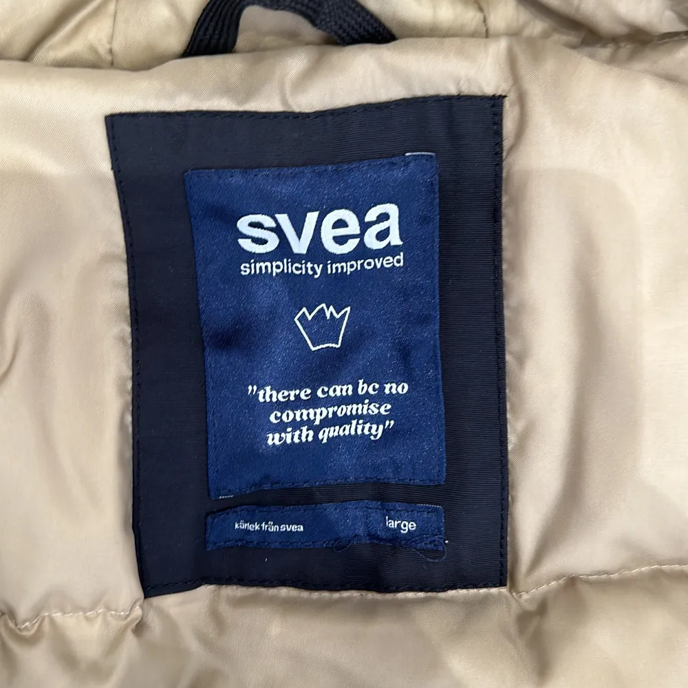 Säljer en svart vinterjacka från Svea med avtagbar huva och pälsdetaljer. Jackan har flera praktiska fickor och en broderad flagga på ärmen. Perfekt för kalla dagar med sin långa passform och varma foder. Storlek: Large . Takit.