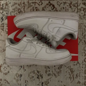 Vita Nike Air Force 1 - Säljer ett par klassiska vita Nike Air Force sneakers. Skorna går enkelt att rengöra för att se nyare ut.