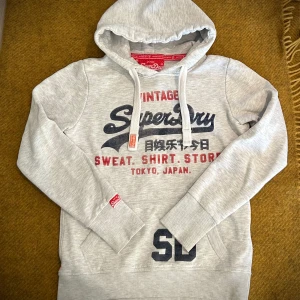 Grå superdry hoodie - Säljer nu denna feta och eftertraktade Superdry Hoodien. Den är i storlek S men passar även Xs. Den är sparsamt använd och har inga defekter endast små tecken på användning. Vid minsta fråga eller fundering är det bara att höra av sig😇