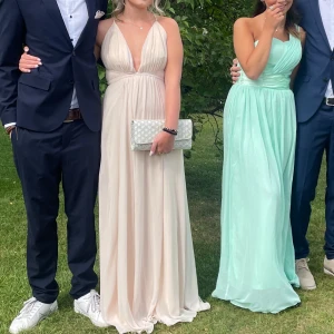 Balklänning!! 💕💕 - Elegant champagnefärgad balklänning med djup v-ringning och öppen rygg. Klänningen har en ärmlös design och ett flytande fall som ger en vacker siluett. Perfekt till balen! Nypris är 1899kr. Hör av er för fler bilder eller funderingar. 💗💗