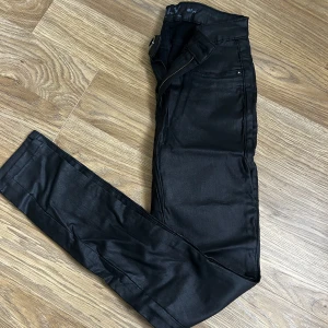 NYA-Svarta jeansbyxor med dragkedja - Snygga svarta byxor som aldrig är använda. Byxorna har en dragkedja och klassiska femficksdetaljer.