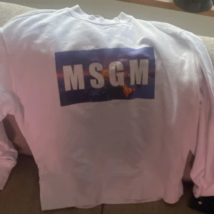 Vit sweatshirt från MSGM - Säljer en vit sweatshirt från MSGM med tryck fram och text bak. Tröjan har långa ärmar och en rund halsringning. Perfekt för en avslappnad stil.