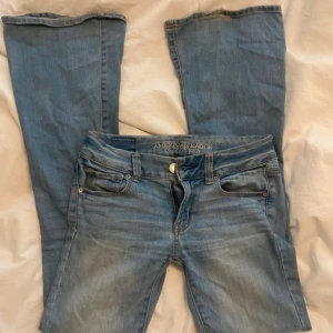 Blå jeans från American Eagle - Snygga blå jeans från American Eagle med klassisk femficksdesign och dragkedja. De har en lätt tvättad look och är perfekta för en avslappnad stil. Passar bra till både sneakers och boots. De är lågmidjade och bootcut💕