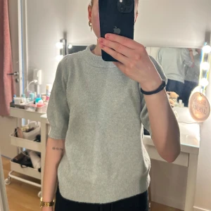 Mintgrön stickad tröja från Vero Moda - Säljer en mint grön stickad tröja från Vero Moda. Tröjan har korta ärmar med lätt puff och ribbade muddar vid hals, ärmslut och nederkant. Perfekt för lager-på-lager och enkel att matcha med olika outfits.