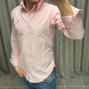 Ralph Lauren Skjorta - Rosa skjorta från Ralph Lauren i strl XS/S och skjortan håller ett mycket bra skick, killen på bilden är 174 cm lång