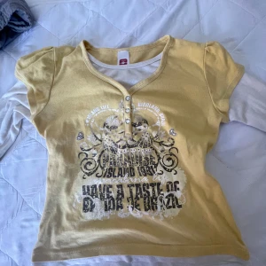 Snygg långarmad topp med tryck - Är som en babydoll topp fast med inbyggda långa ärmar. Står storlek 146/152 men den passar bra och lägger sig fint nedanför naveln på mig som är storlek S.