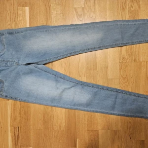 Blå jeans från KappAhl - Snygga blå jeans från KappAhl i en klassisk design. De har en elastisk midja för extra komfort och en smal passform. Perfekta för en avslappnad stil.